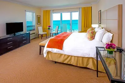 a hotel room with a large bed and a television at Sea View Hotel in Miami Beach