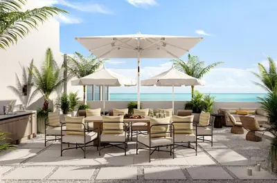 a patio with a table and chairs and an umbrella at Delano Miami Beach in Miami Beach