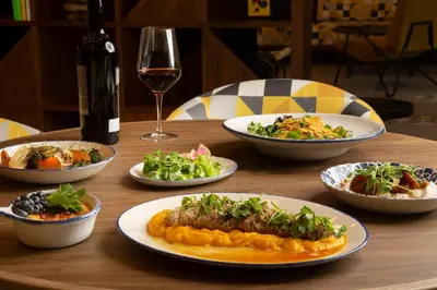 a table with plates of food and a glass of wine at Hotel Indigo Miami Brickell by IHG in Miami