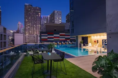a rooftop patio with a table and chairs and a pool at Hotel Indigo Miami Brickell by IHG in Miami