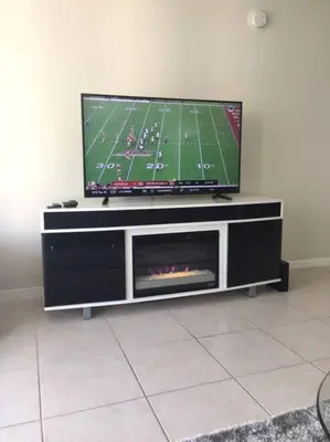 a flat screen tv on a entertainment center with a fireplace at Tides Beachfront Resort - 2 Bedroom Direct Oceanview Condo in Hollywood