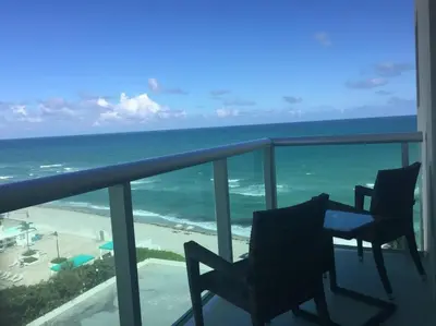 a balcony with two chairs and the ocean at Tides Beachfront Resort - 2 Bedroom Direct Oceanview Condo in Hollywood
