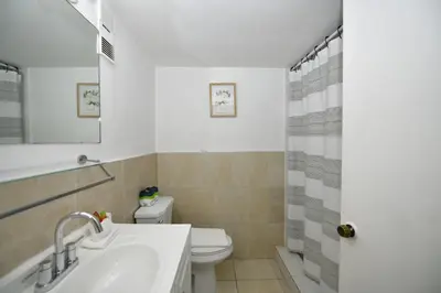 a bathroom with a toilet and a sink and a shower at Sobe Apartments in Miami Beach