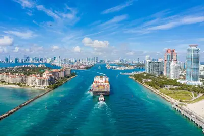 a boat in a river with a city in the background at Sofi Beach Apartments in Miami Beach