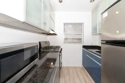 a small kitchen with a stove and a refrigerator at Sofi Beach Apartments in Miami Beach
