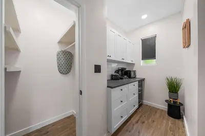 a kitchen with white cabinets and a counter at Greenview Hotel By Lowkl in Miami Beach