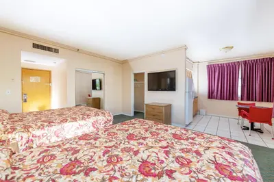 a hotel room with two beds and a flat screen tv at Ocean Beach Suites in Miami Beach
