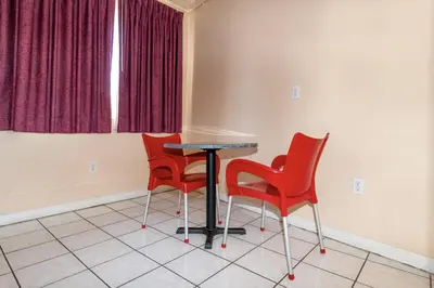 a table and four red chairs in a room at Ocean Beach Suites in Miami Beach
