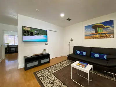 a living room with a black couch and a table at Miami Beach Rooms B&B in Miami Beach