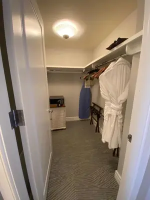 a hallway with a closet with white clothes and a table at Private condo hotel at Four Seasons Brickell in Miami