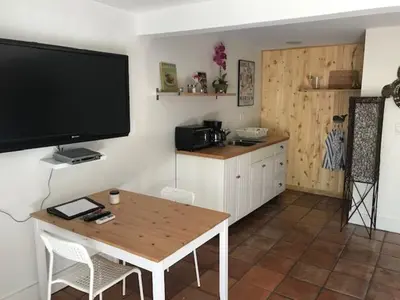 a kitchen with a table and a large television on the wall at Little havana paradise in Miami