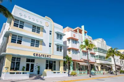 a building on a street with palm trees at Hilton Vacation Club Crescent on South Beach Miami in Miami Beach