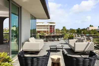 a balcony with chairs and tables on a building at Kimpton - Hotel Palomar South Beach by IHG in Miami Beach