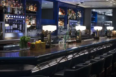 a bar with chairs in a room with liquor bottles at Fontainebleau Miami Beach in Miami Beach