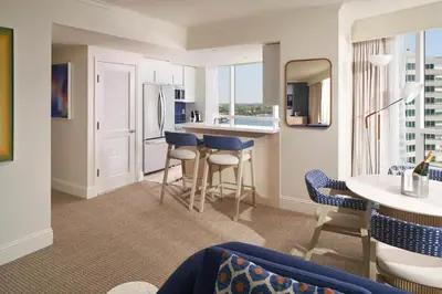 a kitchen and living room with a counter and chairs at Fontainebleau Miami Beach in Miami Beach