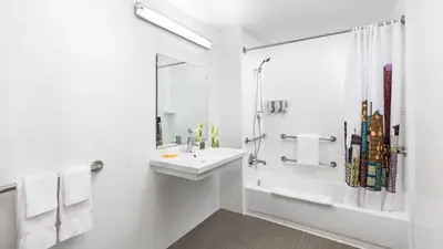 a white bathroom with a sink and a shower at YVE Hotel Miami in Miami