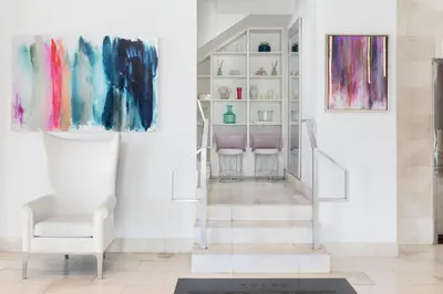 a living room with paintings on the wall and a chair at YVE Hotel Miami in Miami