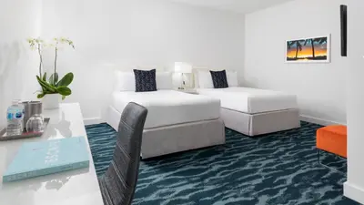 a hotel room with a bed and a desk and a table at YVE Hotel Miami in Miami