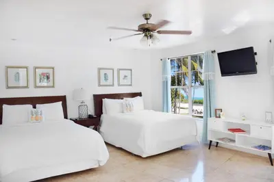 a bedroom with two beds and a flat screen tv at Beach Park Hotel in Miami Beach