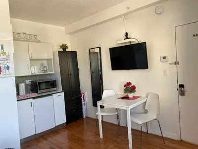 a small kitchen with a white table and chairs at Harding Boutique Apartments in Miami Beach