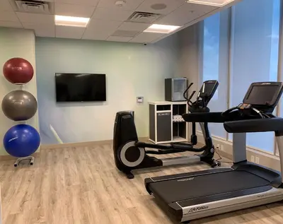 a gym with cardio equipment and a flat screen tv at Wyndham Garden Miami International Airport in Miami