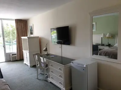 a hotel room with a desk and a mirror at Hotel Chateaubleau in Miami