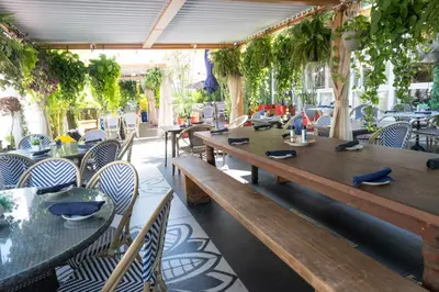 a restaurant with wooden tables and chairs and plants at Catalina Hotel & Beach Club in Miami Beach