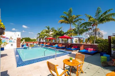a swimming pool with chairs and a table next to a pool at Catalina Hotel & Beach Club in Miami Beach