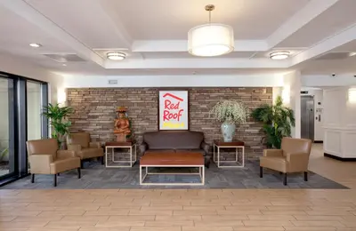 a lobby with a rock food sign on a brick wall at Red Roof PLUS Miami Airport in Miami