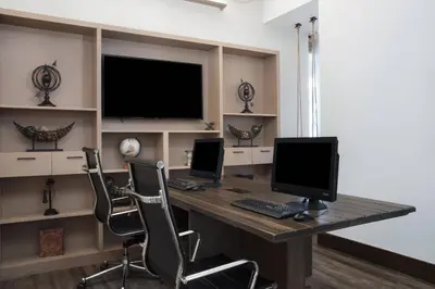 a computer desk with two monitors and two chairs at Four Points by Sheraton Fort Lauderdale Airport/Cruise Port in Fort Lauderdale