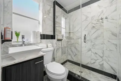 a bathroom with a toilet and a sink and a shower at Shelley Hotel in Miami Beach