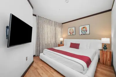 a bedroom with a large bed and a flat screen tv at Metropole Suites South Beach in Miami Beach
