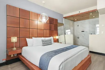 a bedroom with a large white bed and a refrigerator at Chesterfield Hotel & Suites in Miami Beach