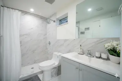 a white bathroom with a toilet and a sink at Designer River View Apartments in Fort Lauderdale