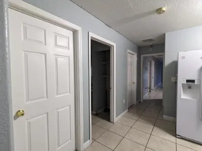 a hallway with a white door and a refrigerator at MiLuSol in Miami