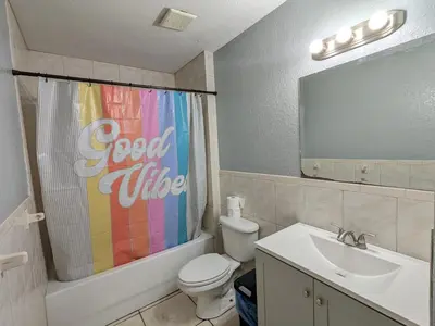 a bathroom with a colorful shower curtain and a toilet and sink at MiLuSol in Miami