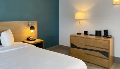 a bedroom with a bed and a desk with a phone at Marseilles Beachfront Hotel in Miami Beach