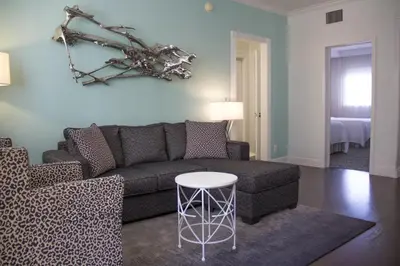 a living room with a couch and a table at Dorchester Hotel & Suites in Miami Beach