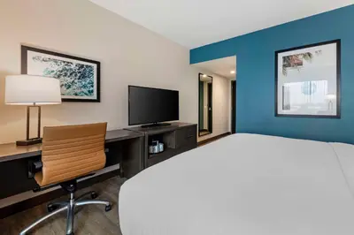 a bedroom with a bed and a desk with a television at Comfort Inn & Suites Miami International Airport in Miami