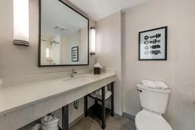a bathroom with a sink and a toilet and a mirror at Comfort Inn & Suites Miami International Airport in Miami