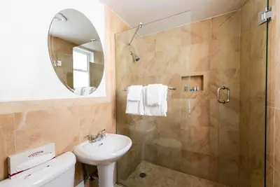a bathroom with a shower and a sink and a mirror at Majestic Hotel South Beach in Miami Beach