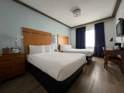 a hotel room with two beds and a desk at Majestic Hotel South Beach in Miami Beach