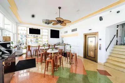 a dining room with tables and chairs and a ceiling fan at Majestic Hotel South Beach in Miami Beach