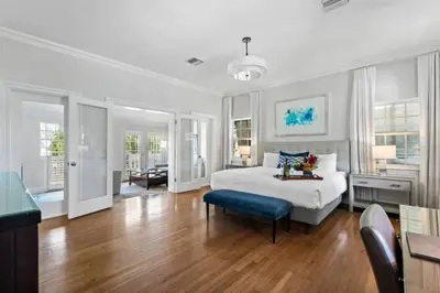 a white bedroom with a bed and a table and chairs at The Pillars Hotel & Club in Fort Lauderdale
