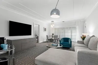 a living room with a couch and a flat screen tv at The Pillars Hotel & Club in Fort Lauderdale