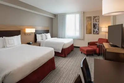 a hotel room with two beds and a flat screen tv at TownePlace Suites Miami Kendall West in Kendall