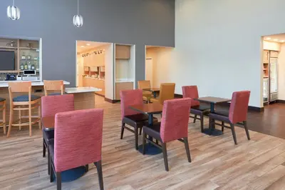 a dining room with red chairs and a table at TownePlace Suites Miami Kendall West in Kendall