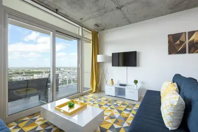 a living room with a blue couch and a large window at Modern 1 Bedroom Midtown Miami with FREE Parking in Miami