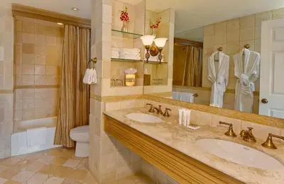 a bathroom with two sinks and a toilet and a mirror at Biltmore Hotel Miami Coral Gables in Miami