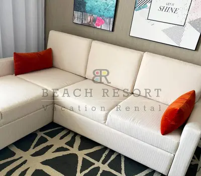 a white couch with two orange pillows in a room at HYDE Beach House Apartments in Hollywood